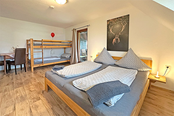 Schlafzimmer mit Doppelbett und Stockbett
